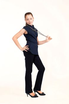 The girl the teenager costs in a suit and holds in hand a beads on a white background