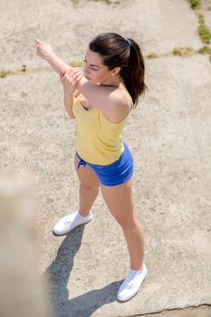 Beautiful young woman doing exercise outdoors. 