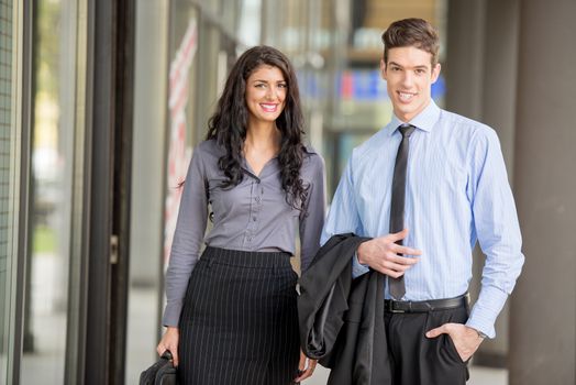 Close-up of a young businessmen and businesswomen walking outside. 