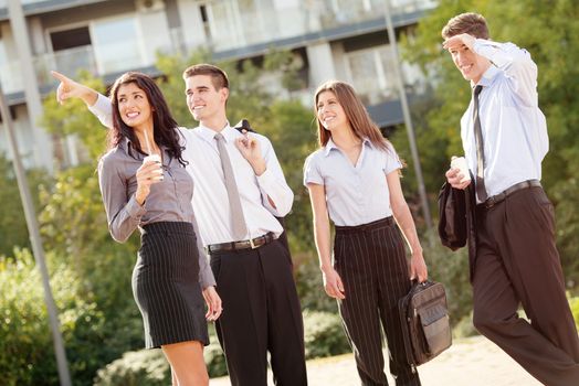 Successful young business team during a coffee break, walking on a park and enjoying a sunny day.