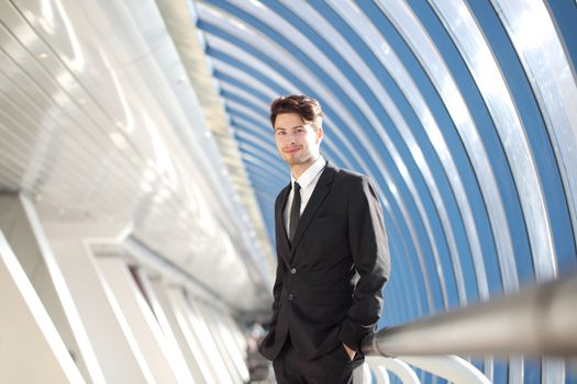 Young Businessman standing in corridor of modern office building