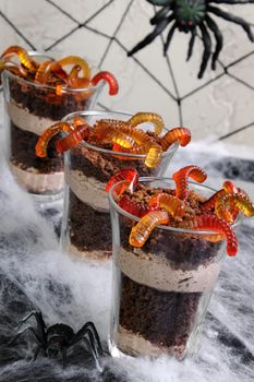 Dessert of chocolate sponge cake with cream and jelly worms