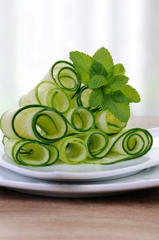 Salad cucumber ribbons twisted in rolls with mint