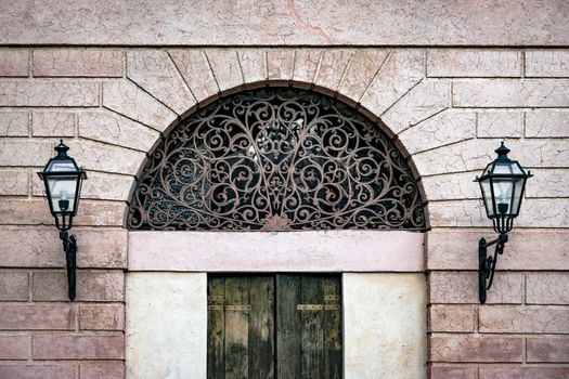 Facade of an ancient Italian villa with artistic iron grill handmade.