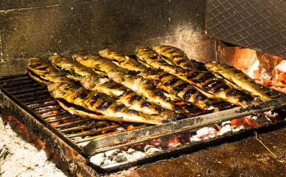 Several stuffed Trouts cooked on wood embers.