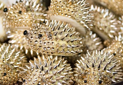 Background formed by golden hedgehogs to use as a paperweight.