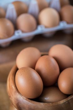 Fresh eggs at wooden plate closeup