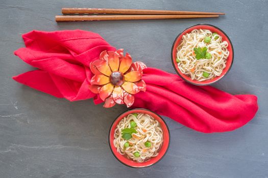 Overhaead view of bowls of asian noodles in a vegetable broth.