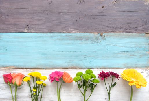 Mixed variety of flowers over a wooden background