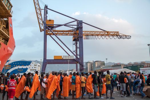ITALY, Palermo: Migrants line up after getting off of the Siem Pilot on April 13, 2016 in Palermo, Italy.The vessel has been a major transporter of migrants fleeing the Middle East and Africa to Europe. 