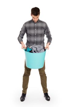 Full length portrait of a young man holding a laundry basket isolated on white background