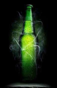 Green bottle of beer on a black background