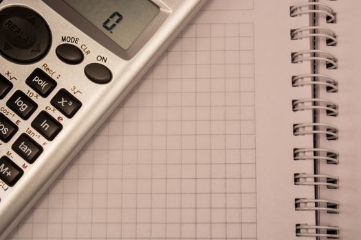 Calculator and white empty notebook, ready to be filled