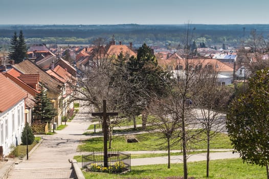 Center of the traditional slovak village, built on a hill. Residential houses and bright green grass.  View from the top of the hill to the city surrounded by nature.