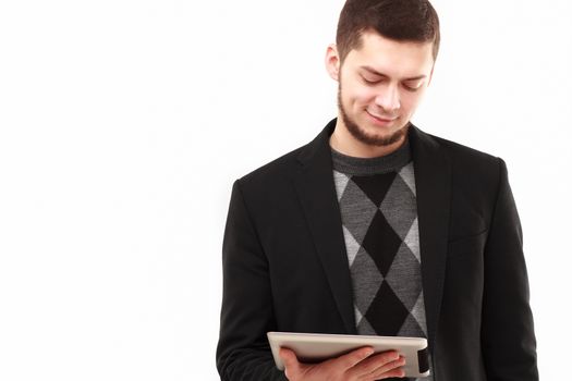 Casual businessman joyfully  looking  at his tablet screen  isolated on white