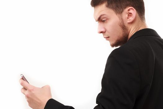 Businessman with a raised eyebrow using his phone isolated on white