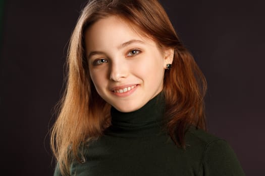 Closeup headshot portrait of redhead woman on dark background