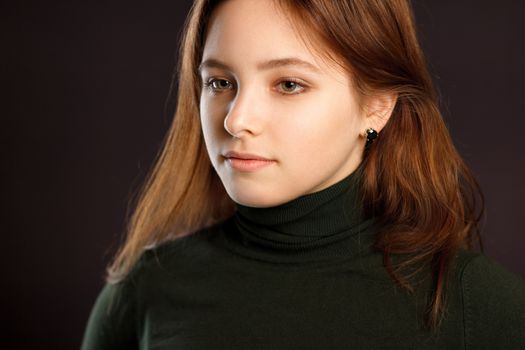 Closeup headshot portrait of redhead woman on dark background