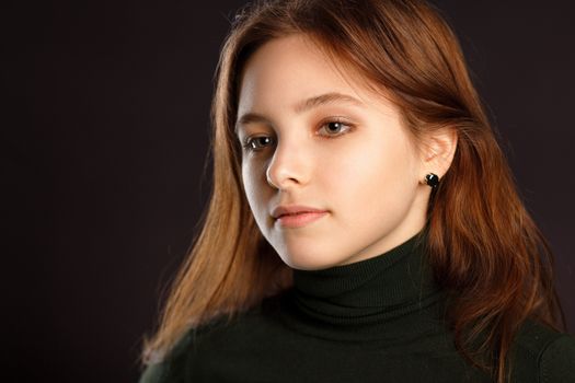 Closeup headshot portrait of redhead woman on dark background