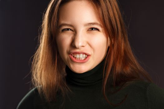 Closeup portrait of young woman showing her teeth and hissing