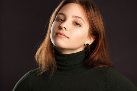 Closeup headshot portrait of redhead woman on dark background