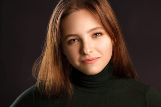 Closeup headshot portrait of redhead woman on dark background