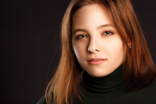 Closeup headshot portrait of squinting redhead woman on dark background