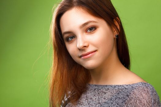 Portrait of young smiling girl on green
