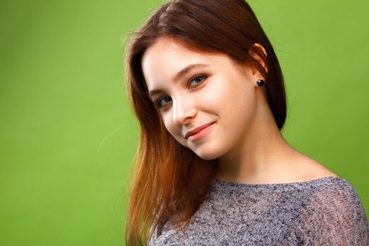 Portrait of young smiling girl on green