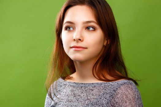 Portrait of young smiling girl on green