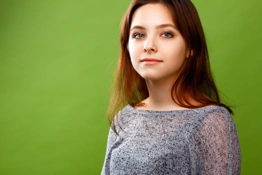 Portrait of young smiling girl looking right on green
