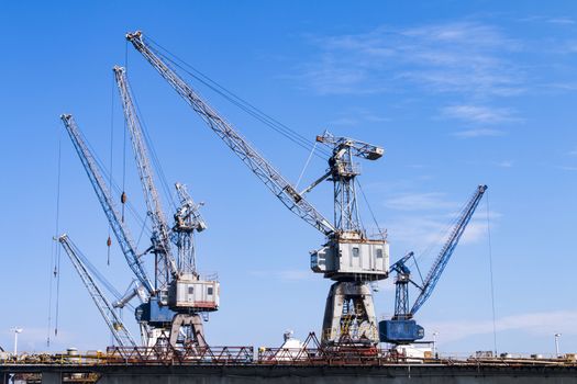 side view of a floating boat or ship repair port with five cranes in view