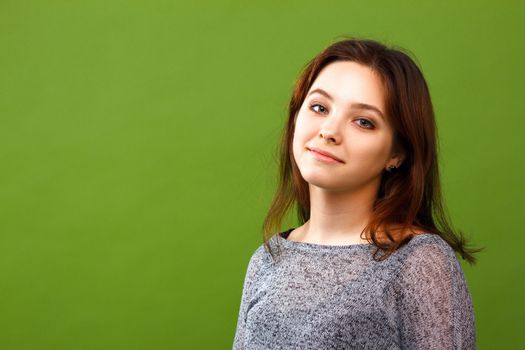 Portrait of young smiling girl on green