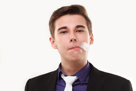 Portrait of a man in suit smoking an e-cigarette isolated on white. Let the steam out of his mouth