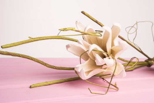 Elegant spring flower, fake gardenia on rustic wooden table. For wedding background image.