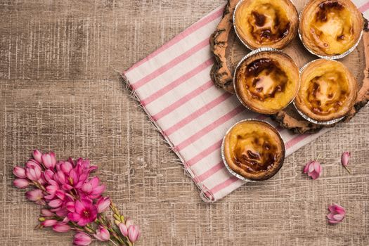 Pasteis de nata, typical Portuguese egg tart pastries on a set table. Top view with copy space