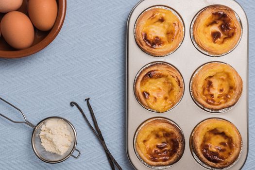 Pasteis de nata, typical Portuguese egg tart pastries from Lisbon on a set table. Top view with copy space