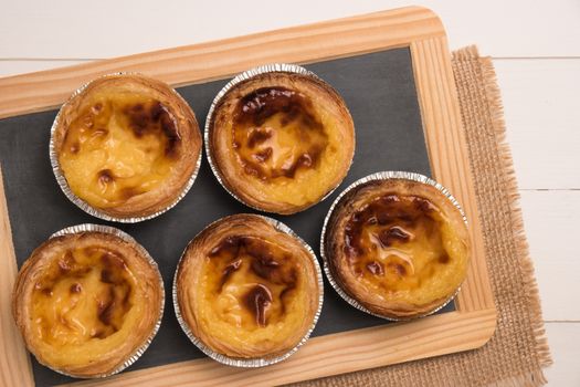 Pasteis de nata, typical Portuguese egg tart pastries on a set table. Top view with copy space