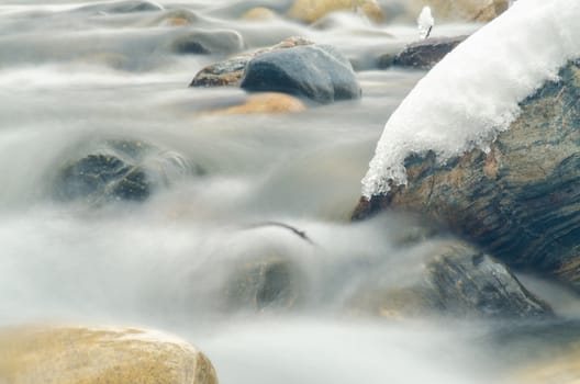 Close-up of the current between the stones of a mountain stream, photographed with a long exposure