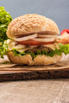 Homemade vegetarian burgers with fresh organic vegetables on rustic wooden background