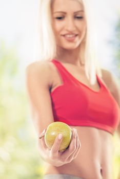 Woman holding apple. Focus on apple. Dieting concept. 