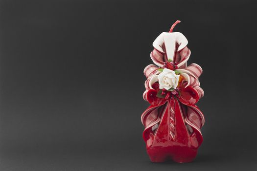 A Christmas candle and red and white color with a rose in the center