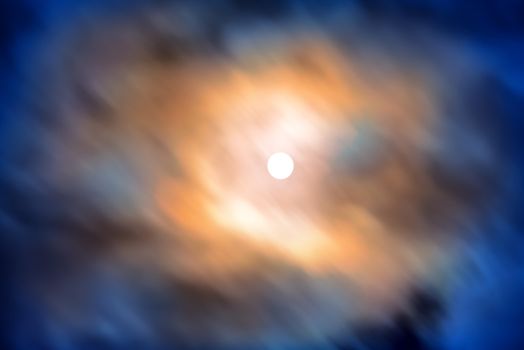 Night view at the full moon through moving blue clouds. Abstract scene