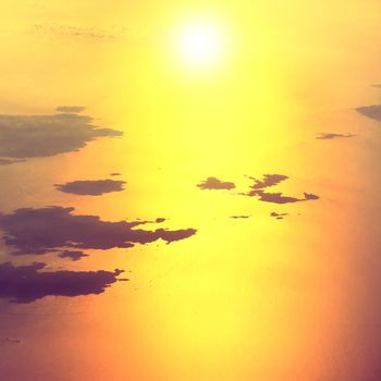 View from a plane to sunset on the sky. Fluffy clouds background