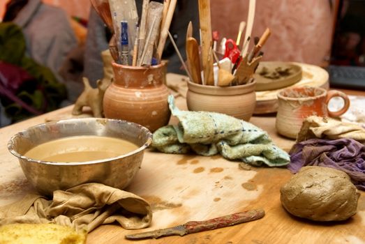 Handmade old clay pots with pencils and other stuff on the table