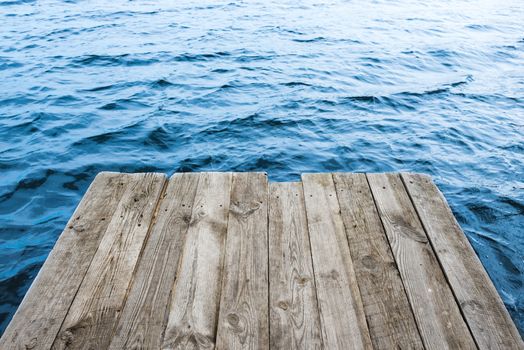 Blue water with empty wooden platform. Natural background