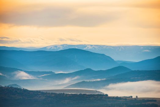 Blue mountains covered with mist against sunset