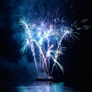 Blue colorful holiday fireworks on the black sky background.