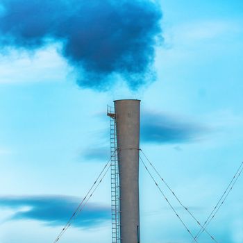 Industrial black toxic smoke from coal power plant on blue sky