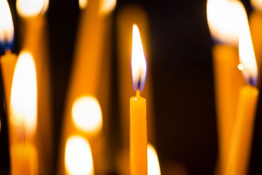 Light of candles in the church on the black background